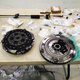 Lighter is better: the new manual clutch sits next to the old PDK flywheel on a table littered with assorted parts for the swap. Photo credit: BGB Motorsports